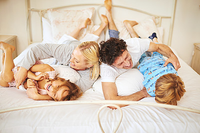 Buy stock photo Morning, happy and family in bed with kids, parents and play for bonding in bedroom. Couple, children and smiles for together, love and support in home on weekend for relaxing, break and happiness