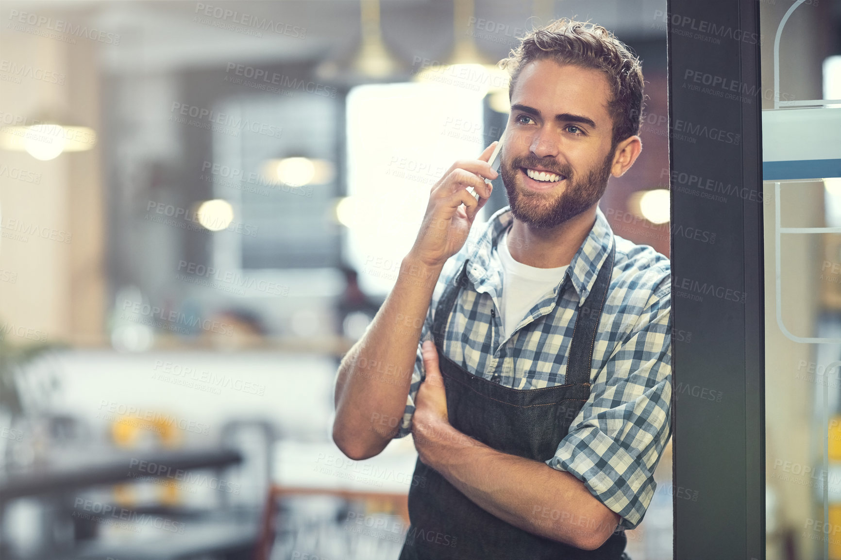 Buy stock photo Shot of a young man using a phone in the store that he works at