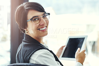 Buy stock photo Portrait of a young businesswoman working on a digital tablet in a modern office
