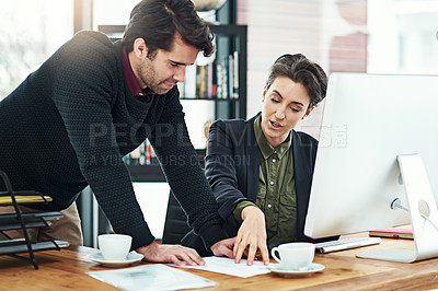 Buy stock photo Cropped shot of two businesspeople discussing work at a desk in their office