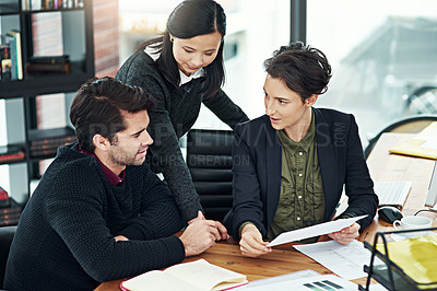 Buy stock photo Cropped shot of a team of businesspeople discussing work at a desk in their office