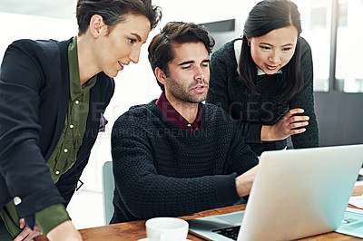 Buy stock photo Cropped shot of a team of businesspeople discussing work at a desk in their office