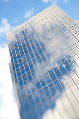 Buy stock photo Building, city and low angle with clouds, mirror and sky with postmodern architecture for urban expansion. Skyscraper, reflection and future with property, windows and flare with real estate in USA