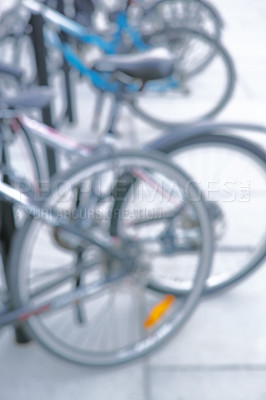 Buy stock photo Bicycle, parking rack and street with row for eco friendly travel, security and sustainability with blur. Bike, city and urban sidewalk with transportation, carbon footprint and wheels in Spain