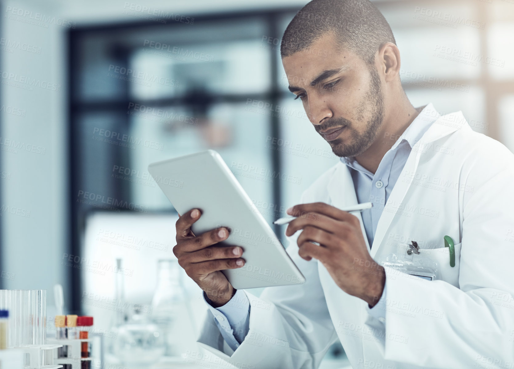 Buy stock photo Shot of a scientist recording his findings on a digital tablet