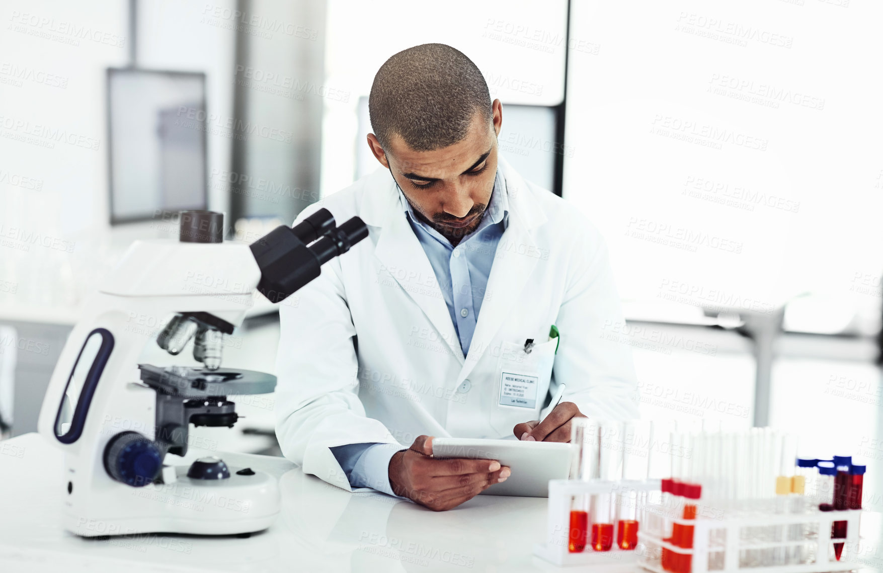 Buy stock photo Scientist writing DNA results from microscope test on a tablet.Professional male doctor in a lab working with research tubes.Man in a modern laboratory doing medical science data analysis.