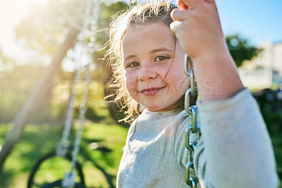 Buy stock photo Portrait of a cute little girl sitting on a swing in a park