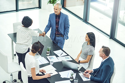 Buy stock photo Cropped shot of businesspeople shaking hands during an office meeting
