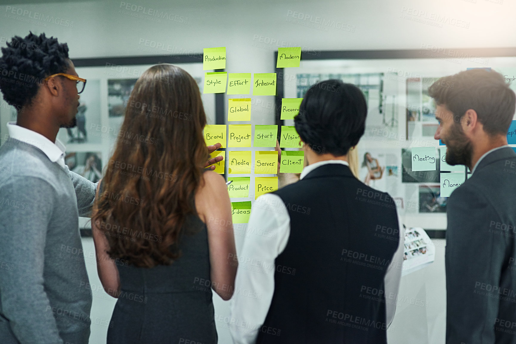 Buy stock photo Cropped shot of colleagues brainstorming with adhesive notes on a glass wall in a modern office