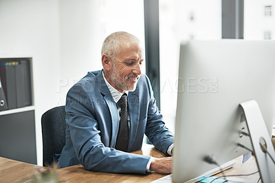 Buy stock photo Cropped shot of a mature businessman working on a computer in a modern office