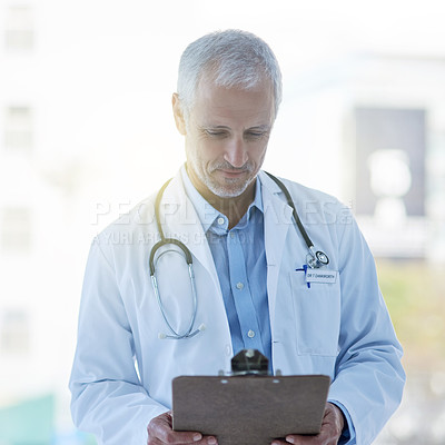 Buy stock photo Doctor, clipboard and stethoscope in hospital for medical research, examination or consultation with records. Physician, male person and mature at health, chart and results for healthcare or medicine