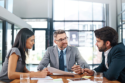 Buy stock photo Cropped shot of three businesspeople meeting in the boardroom