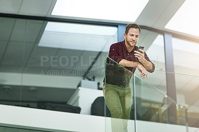 Buy stock photo Shot of a businessman using his cellphone in a modern office