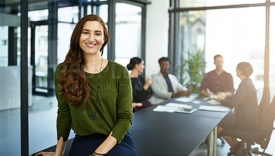 Buy stock photo Portrait of a businesswoman in a boardroom with her colleagues blurred out in the background