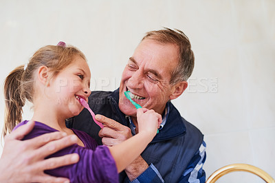 Buy stock photo Shot of a father and his young daughter brushing their teeth together