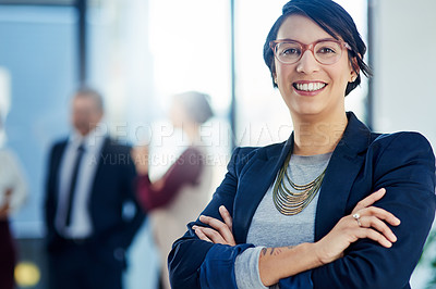 Buy stock photo Cropped shot of a businesswoman standing with her arms crossed and her colleagues in the background