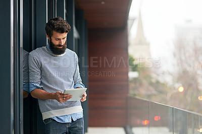 Buy stock photo Cropped shot of a young creative working on a digital tablet outside