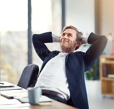 Buy stock photo Shot of a happy businessman leaning back in his chair