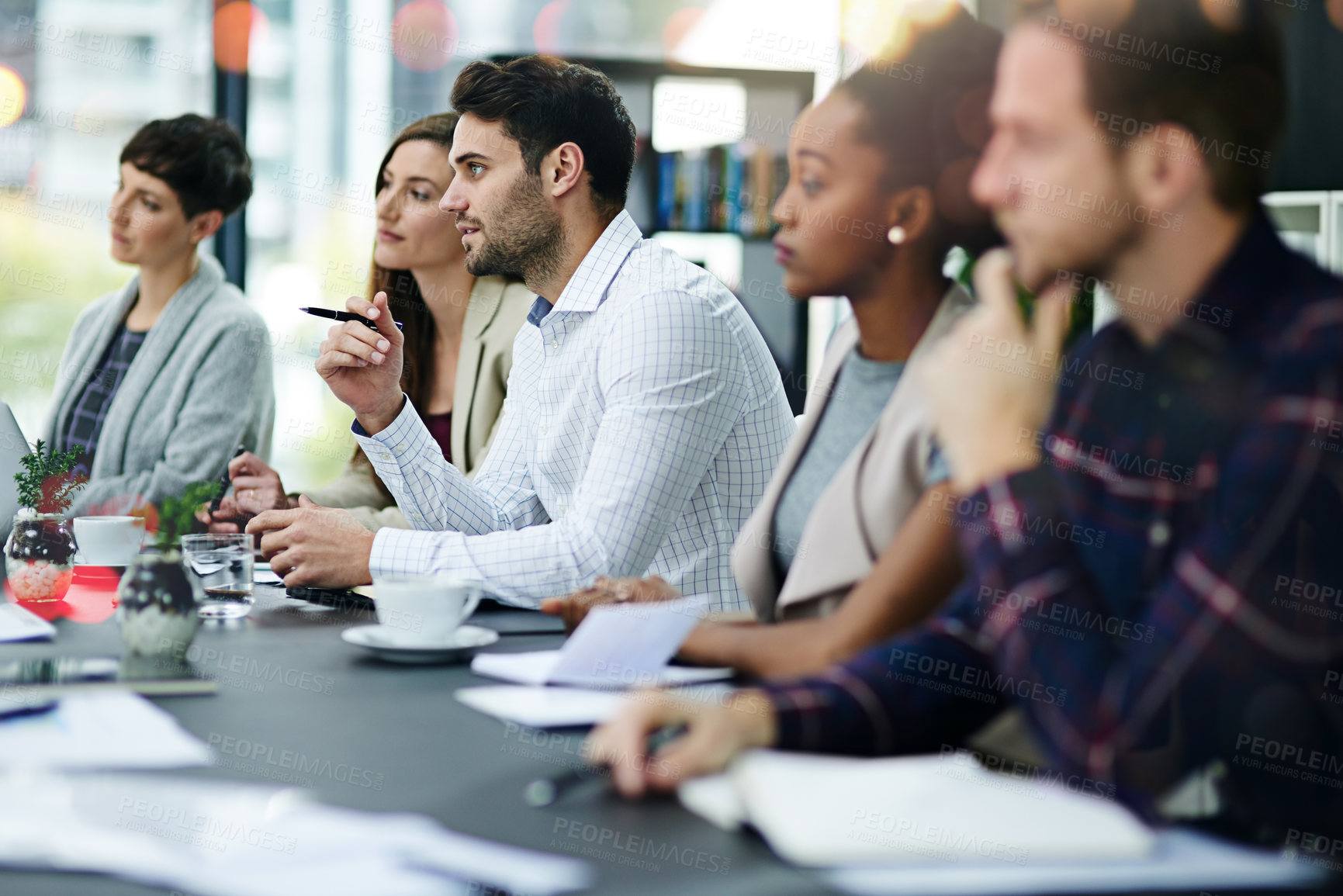 Buy stock photo Cropped shot of a group of businesspeople sitting together in a boardroom meeting