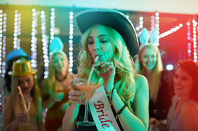 Buy stock photo Shot of a young woman drinking a cocktail at her bachelorette party