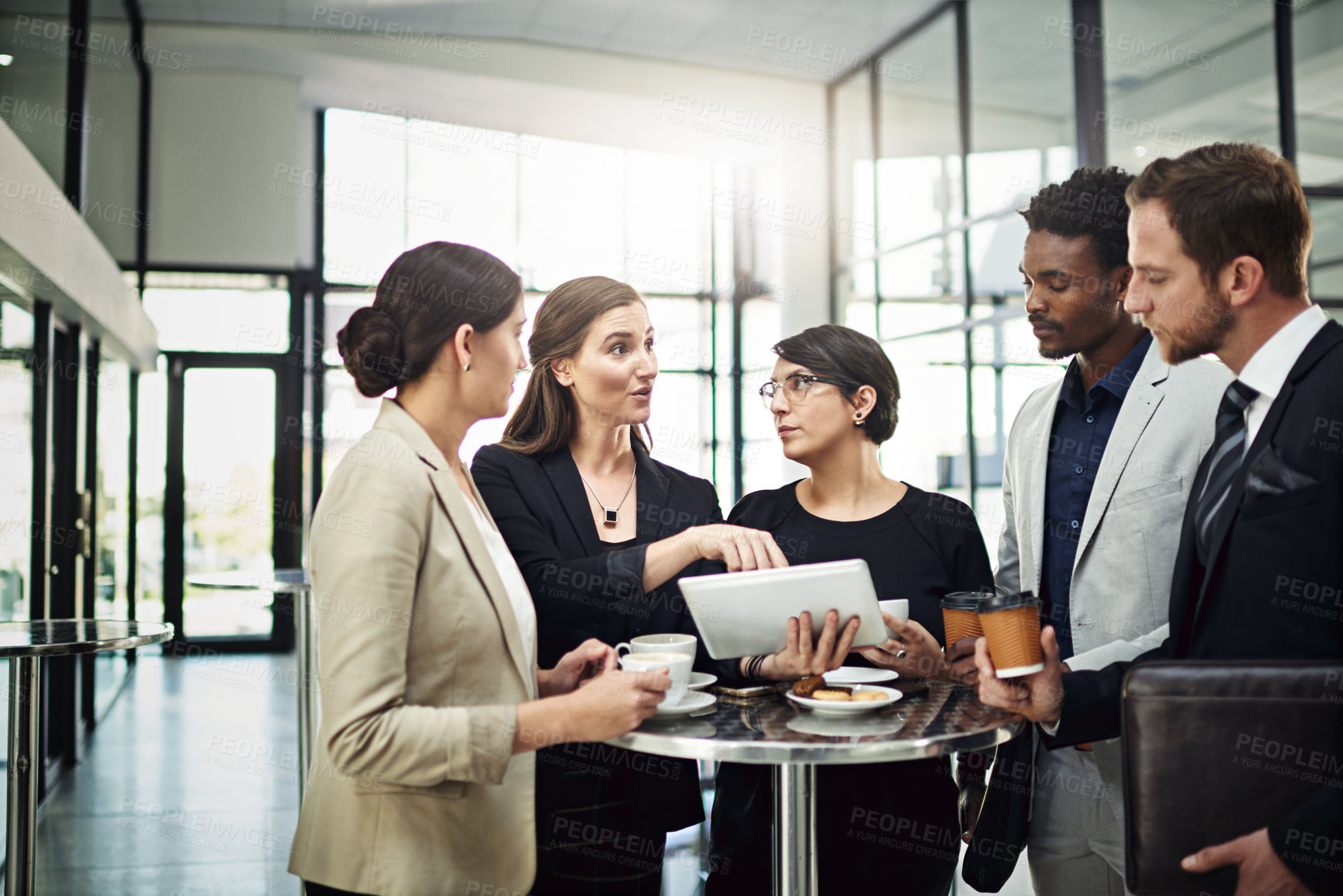 Buy stock photo Cropped shot of a group of businesspeople looking at a tablet in the office