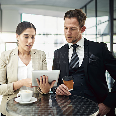 Buy stock photo Cropped shot of two businesspeople looking at a tablet in the office