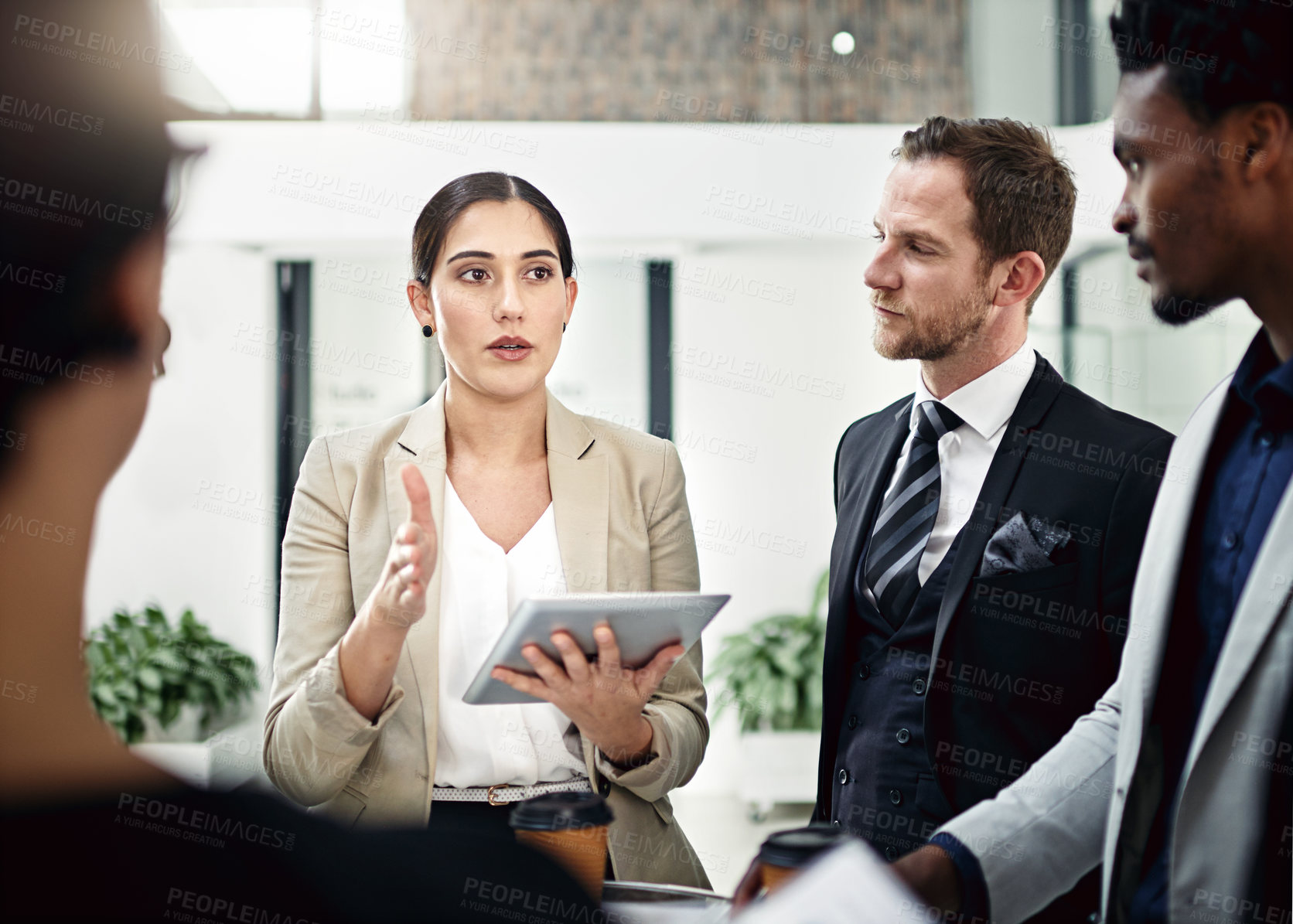 Buy stock photo Cropped shot of a group of businesspeople looking at a tablet in the office