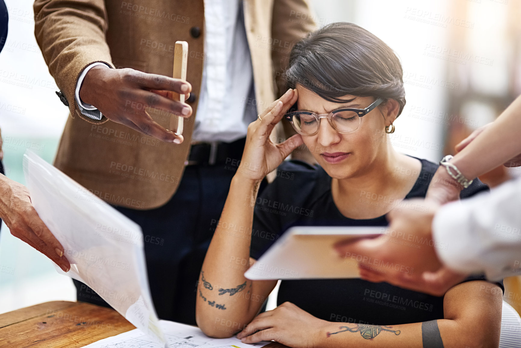 Buy stock photo Cropped shot of a stressed out businesswoman surrounded by colleagues needing help in an office