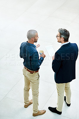 Buy stock photo High angle shot of two businessmen talking in the office