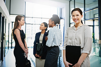 Buy stock photo Portrait of a confident businesswoman standing in the office with her colleagues in the background