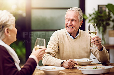 Buy stock photo Shot of an elderly couple enjoying a meal and wine together at home