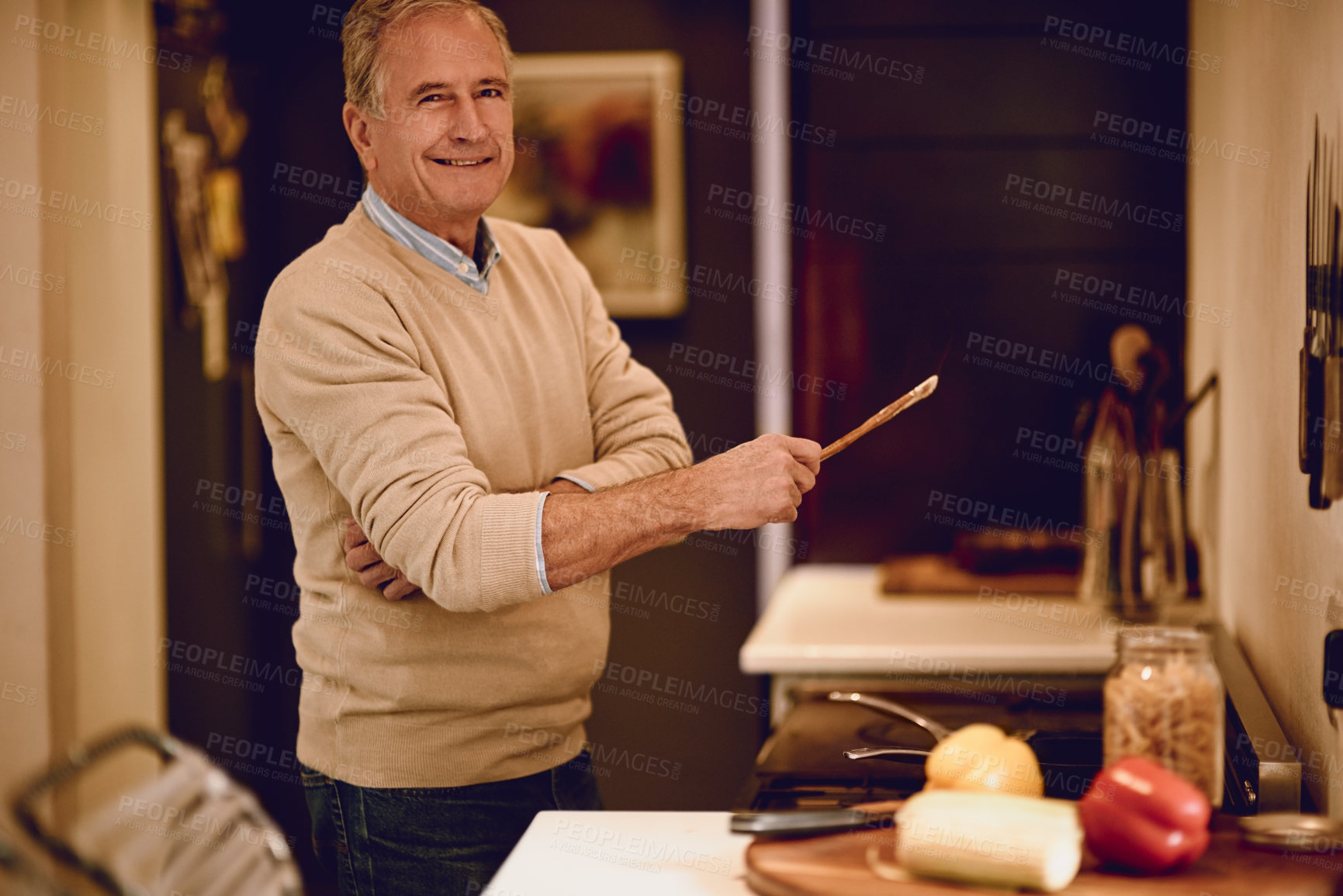 Buy stock photo Portrait of an elderly man cooking a meal in his kitchen
