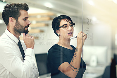 Buy stock photo Cropped shot of businesspeople brainstorming with notes on a glass wall in an office