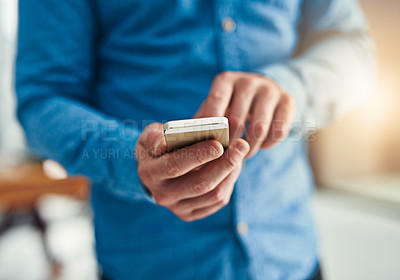 Buy stock photo Closeup shot of a businessman texting on a cellphone in an office