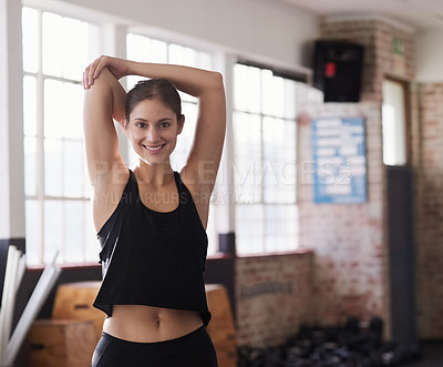 Buy stock photo Shot of a young woman doing static stretches before working out
