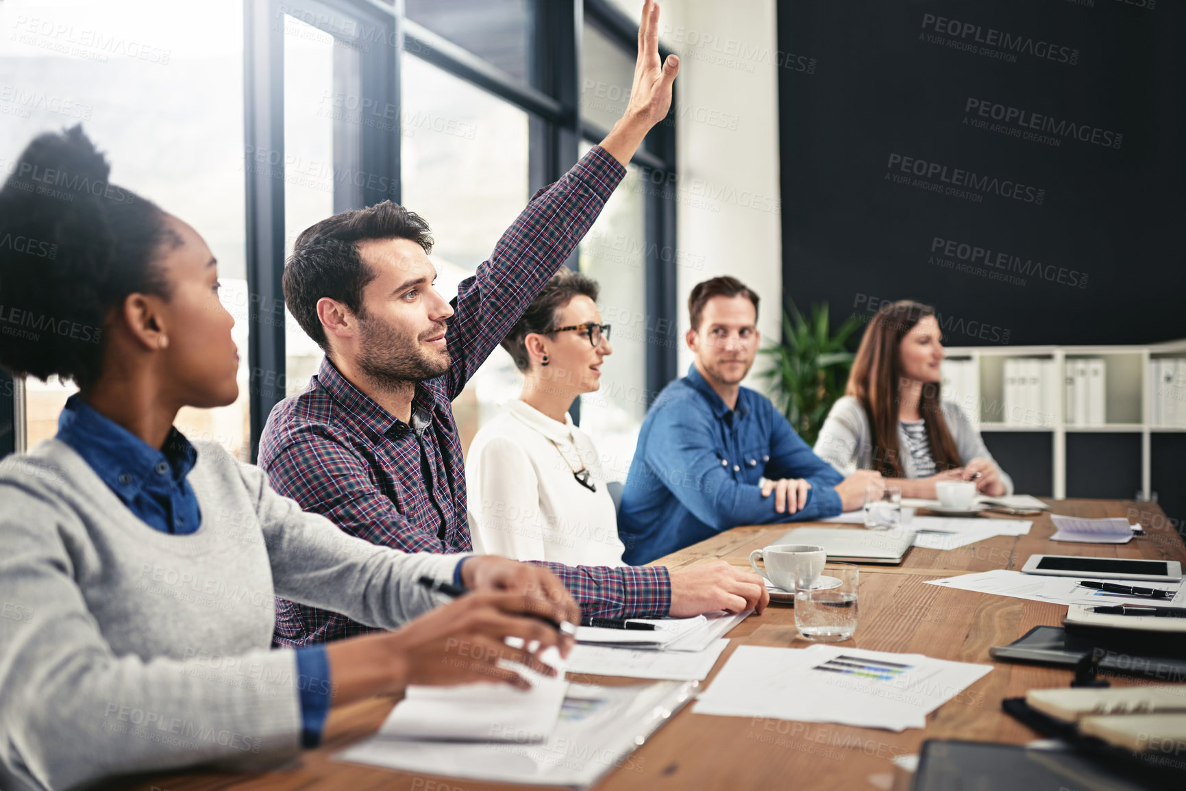 Buy stock photo Businessman, team diversity and raising hand for question in boardroom, office and workspace for faq. Businesspeople, meeting and query or point for finances with smile, notebook and collaboration