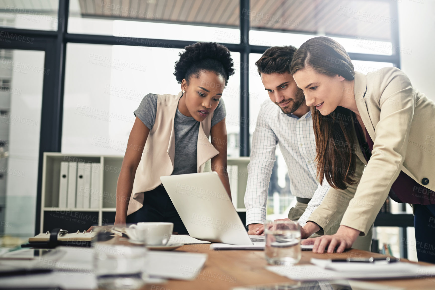 Buy stock photo Shot of a team of businesspeople using a laptop together at work