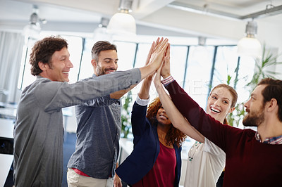 Buy stock photo Shot of a team of businesspeople giving each other a high five in the office