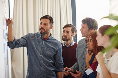 Buy stock photo Shot of a group of businesspeople listening to a colleague's presentation in the office