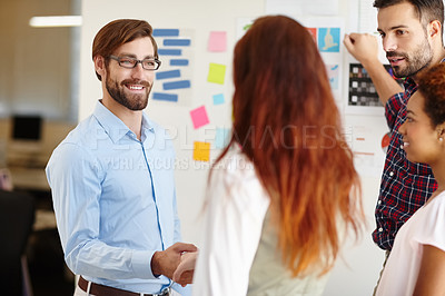 Buy stock photo Shot of a businessman shaking hands with a colleague at work