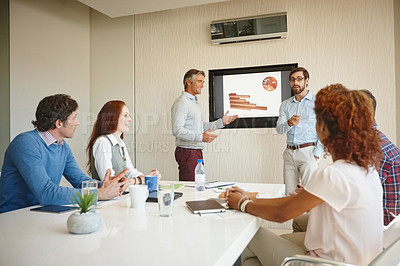 Buy stock photo Shot of two businessmen giving a presentation to their colleagues at work