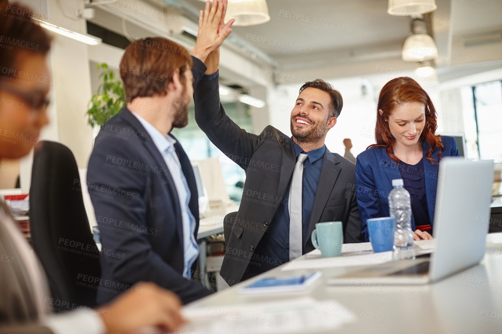 Buy stock photo Shot of colleagues giving each other a high five during a meeting at work