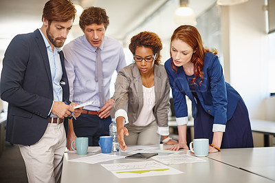Buy stock photo Shot of a group of colleagues going over paperwork during a meeting at work