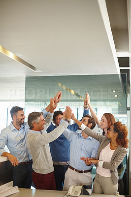Buy stock photo Shot of a group of colleagues giving each other a high five at work