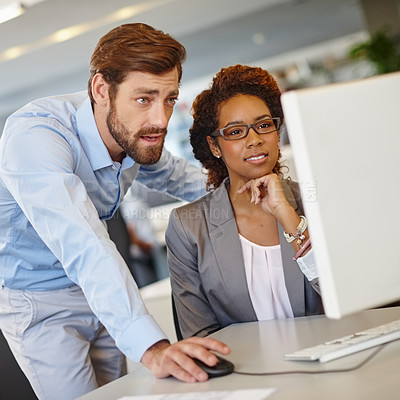 Buy stock photo Shot of two coworkers using a computer together at work