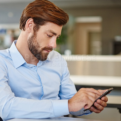 Buy stock photo Shot of a businessman using a mobile phone at his work desk
