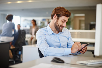 Buy stock photo Shot of a happy businessman using a mobile phone at his work desk