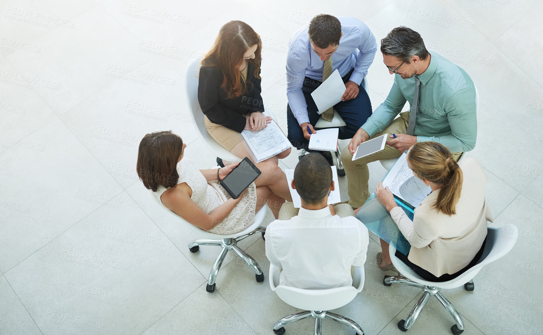 Buy stock photo High angle shot of a group of businesspeople meeting in the office