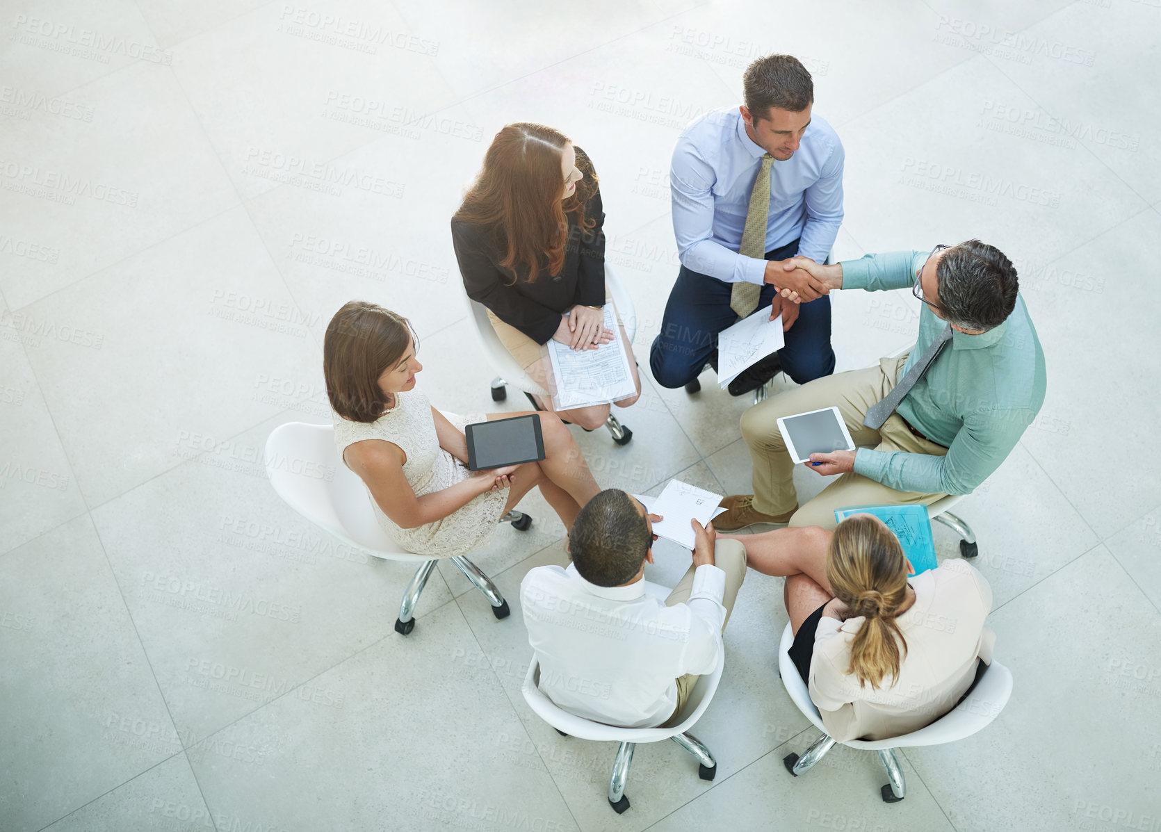 Buy stock photo High angle shot of a group of businesspeople meeting in the office