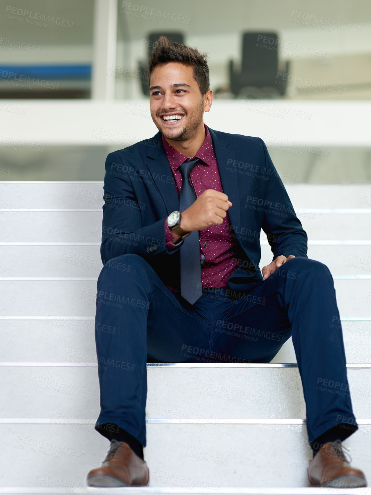 Buy stock photo Shot of a handsome young businessman sitting on a staircase in an office